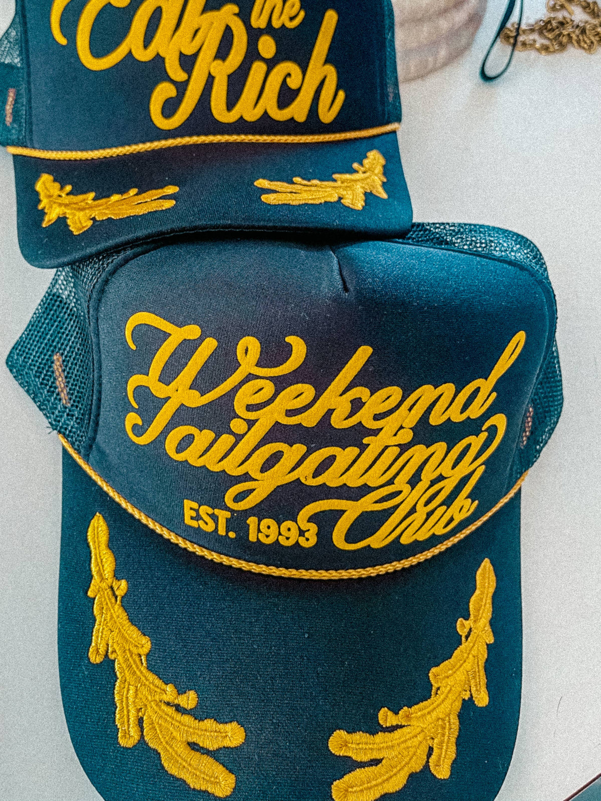 Weekend Tailgating Club, Game Day Trucker Hat: Black/Gold Leaf
